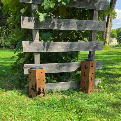 Rustic metal turkey themed solar pillars outdoors showing alternate sides in front of grape vines