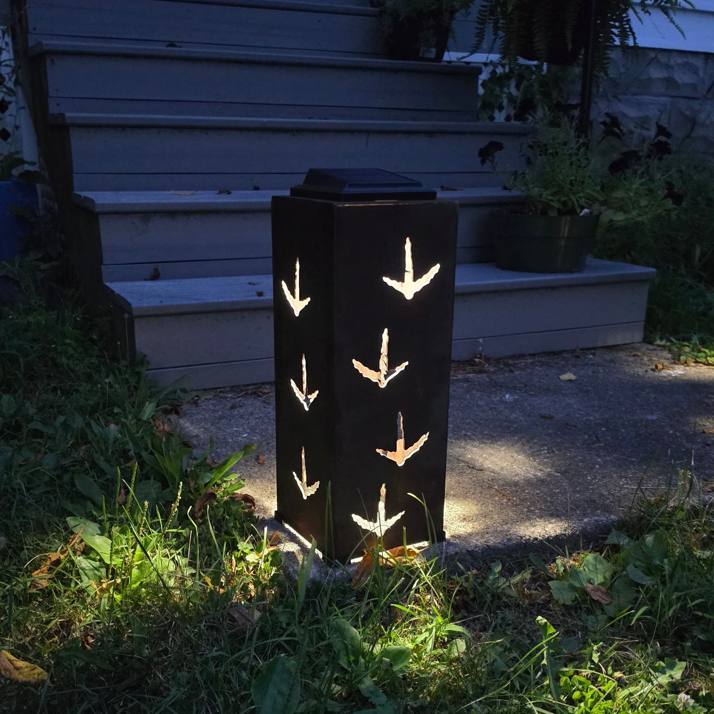 Rustic solar pillar on front patio at dusk glowing with turkey prints 