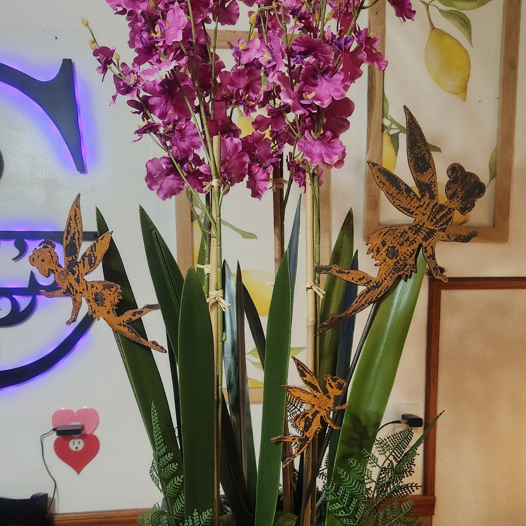 Fairy rustic metal garden stakes in potted plant.