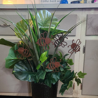 Potted plant with decorative metal bee sculptures in a kitchen setting