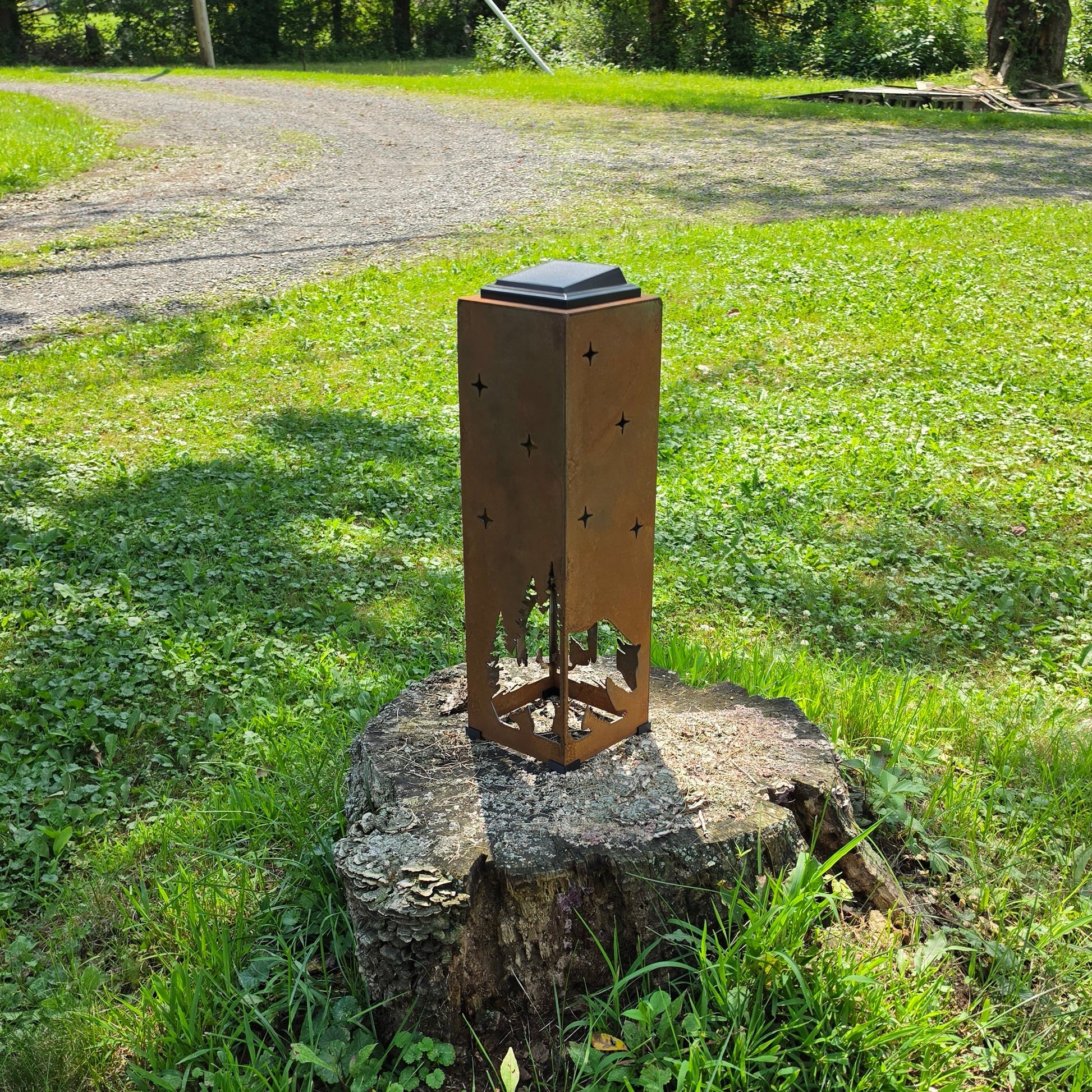 Rustic Metal Bear themed solar pillar on a stump outdoors showing the reverse side