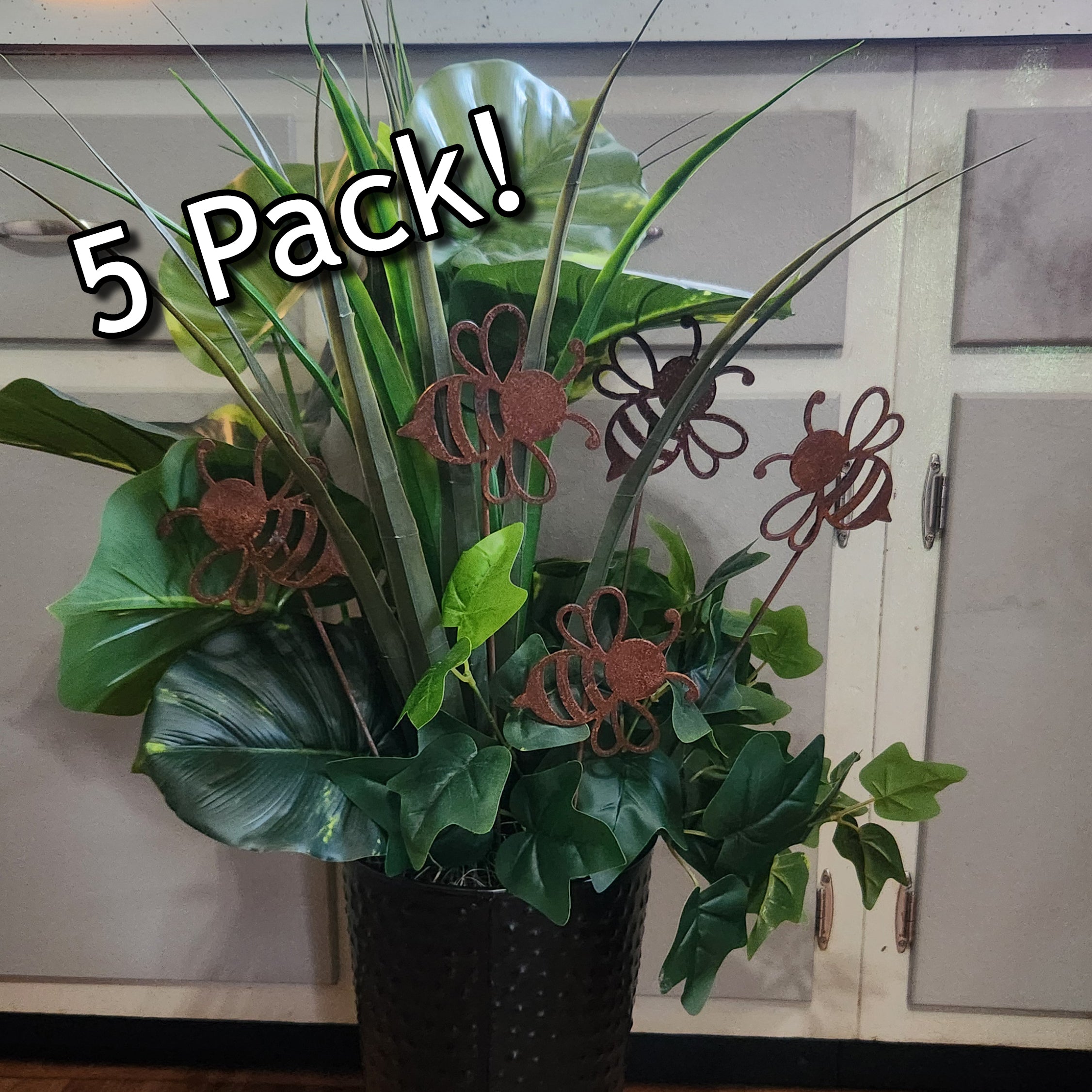 Potted plant with decorative metal bee stakes.
