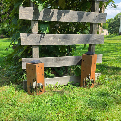 Two rustic metal bear themed solar Pillars outdoors by the Grape Vine