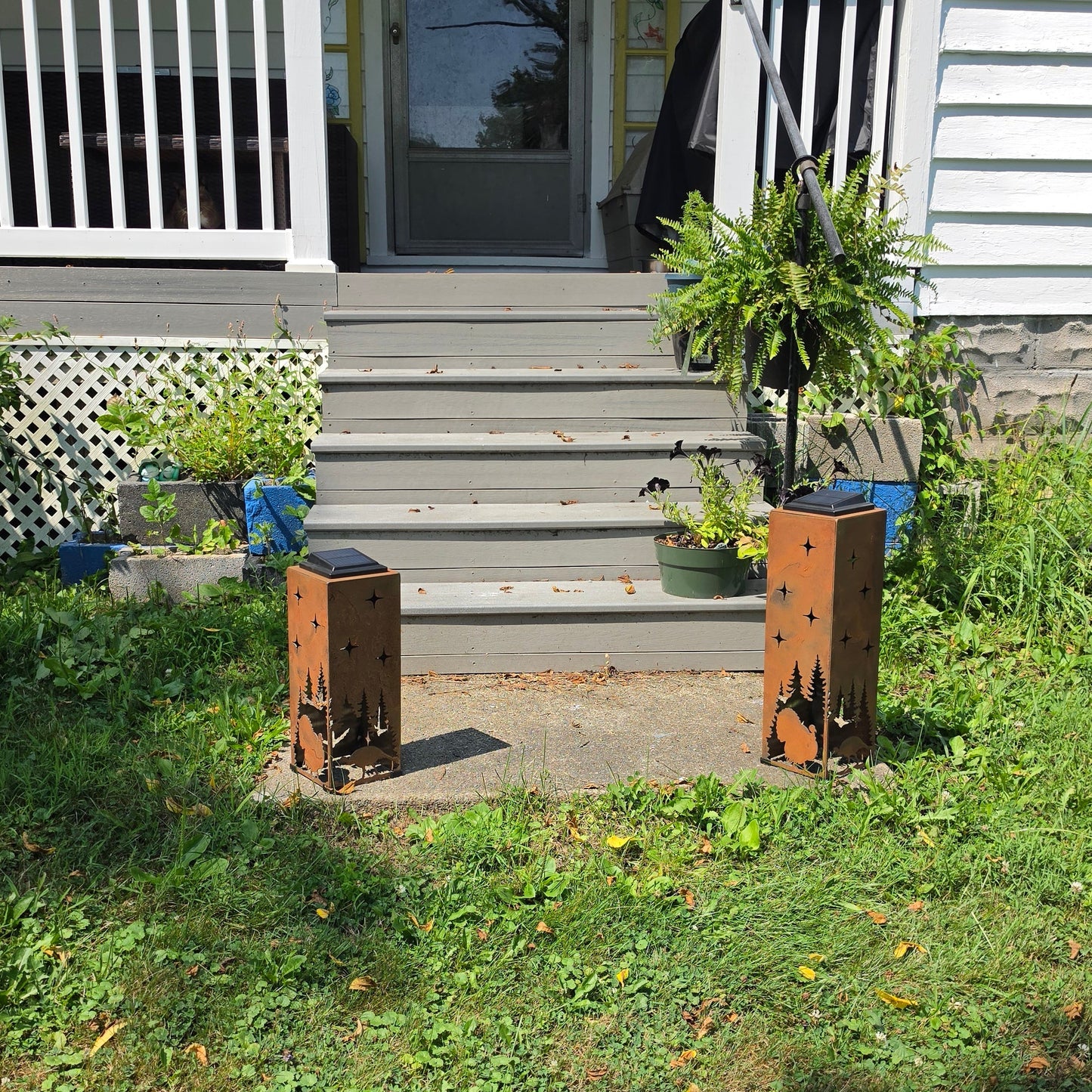 Two turkey themes rustic solar pillars both front facing placed on a front patio