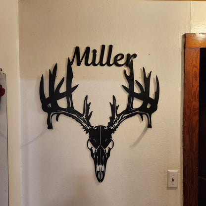 Decorative wall art of a deer skull with 'Miller' on a white wall.