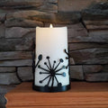 Black powder coated metal candle wrap with dandelions on it.