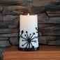 Black powder coated metal candle wrap with dandelions on it.
