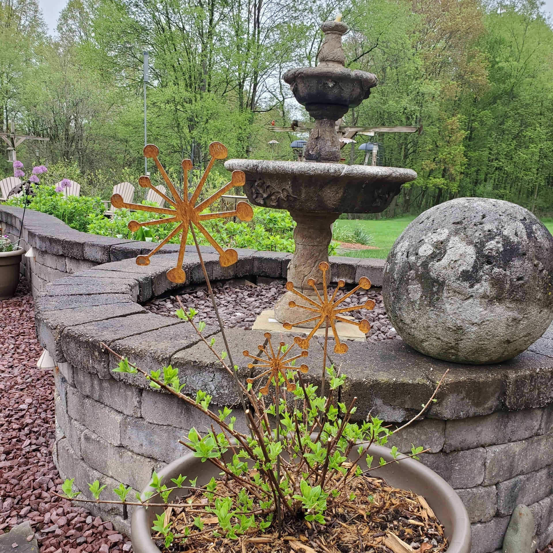Rustic metal plant stakes in front of a fountain