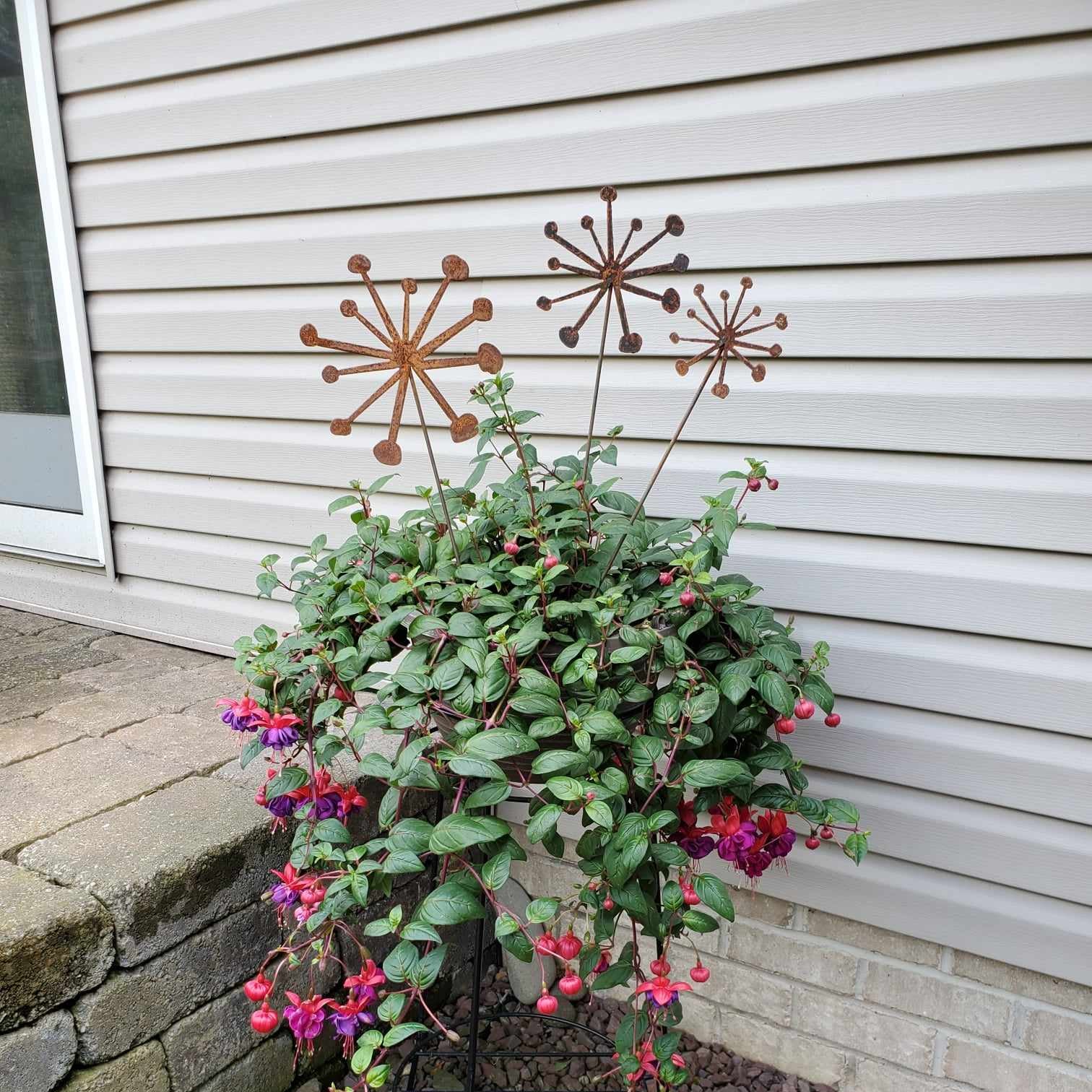 rustic metal dandelion plant stakes in a set of three