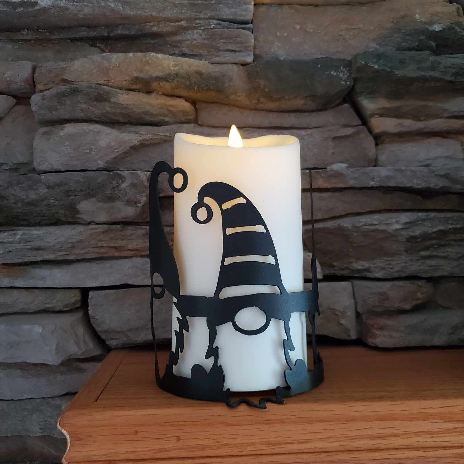 Black metal candle wrap with gnomes on it