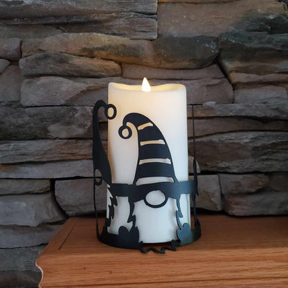 Black metal candle wrap with gnomes on it