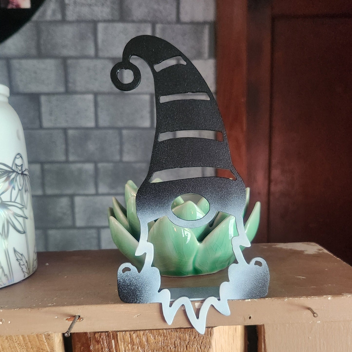 Sitting gnome with beard hanging over shelf