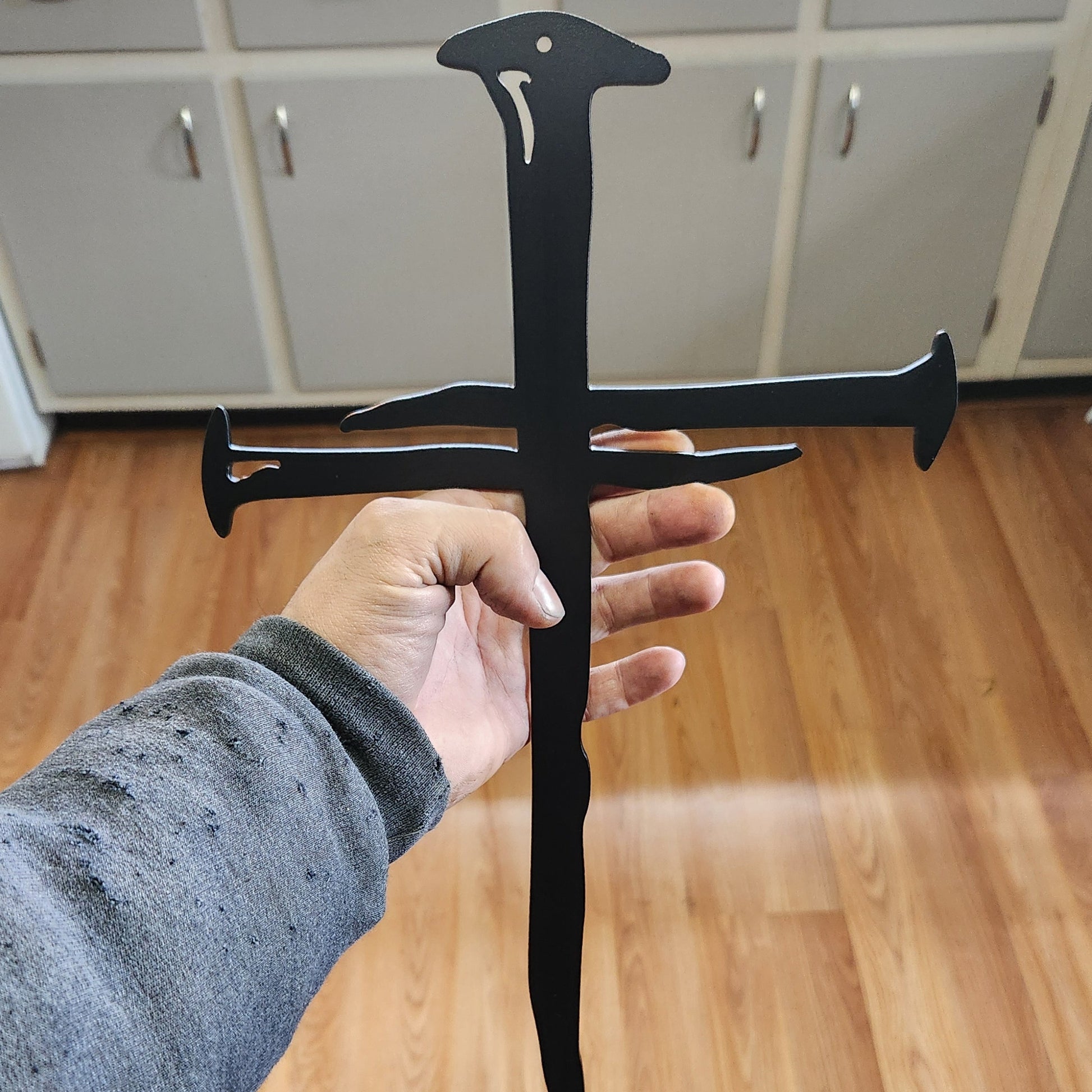 Large black steel cross shaped like a nail