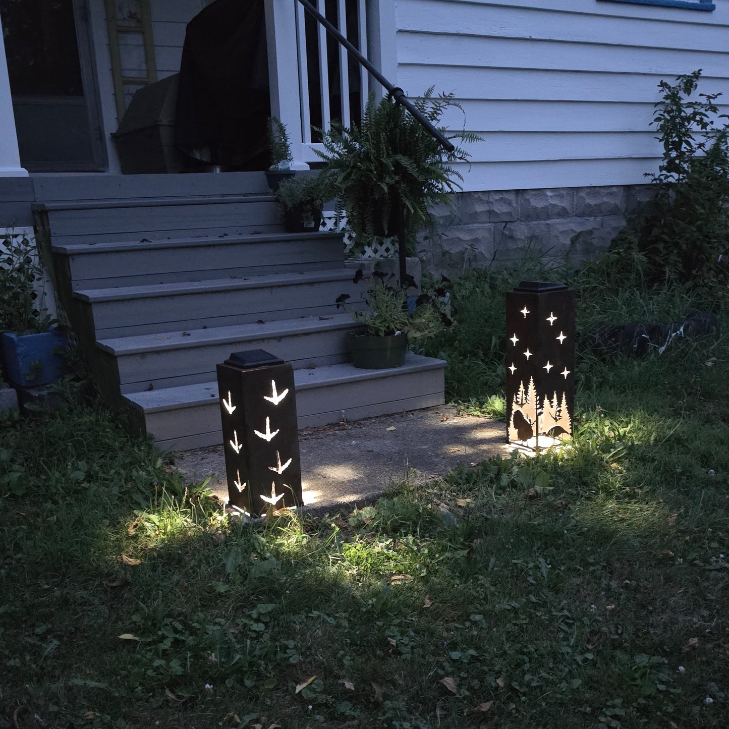 Rustic Solar Pillars at dusk on front patio with a turkey design