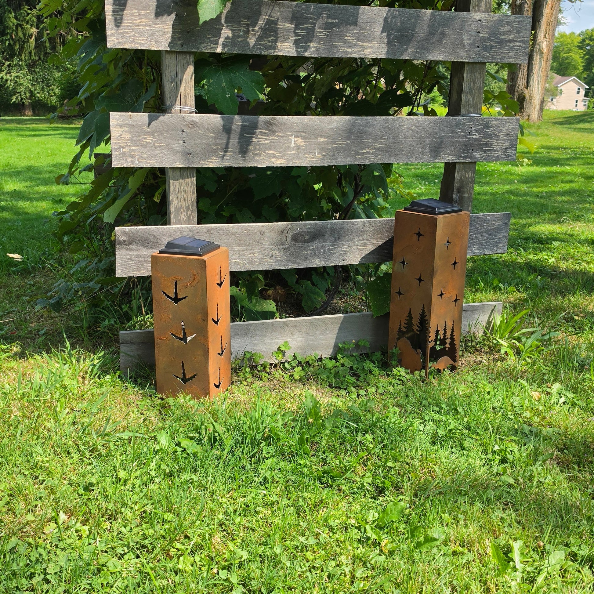 Rustic turkey themed solar pillars showing the alternate sides outdoors in front of grape vines
