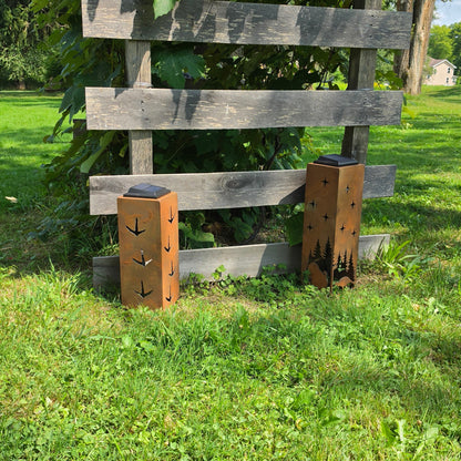 Rustic turkey themed solar pillars showing the alternate sides outdoors in front of grape vines