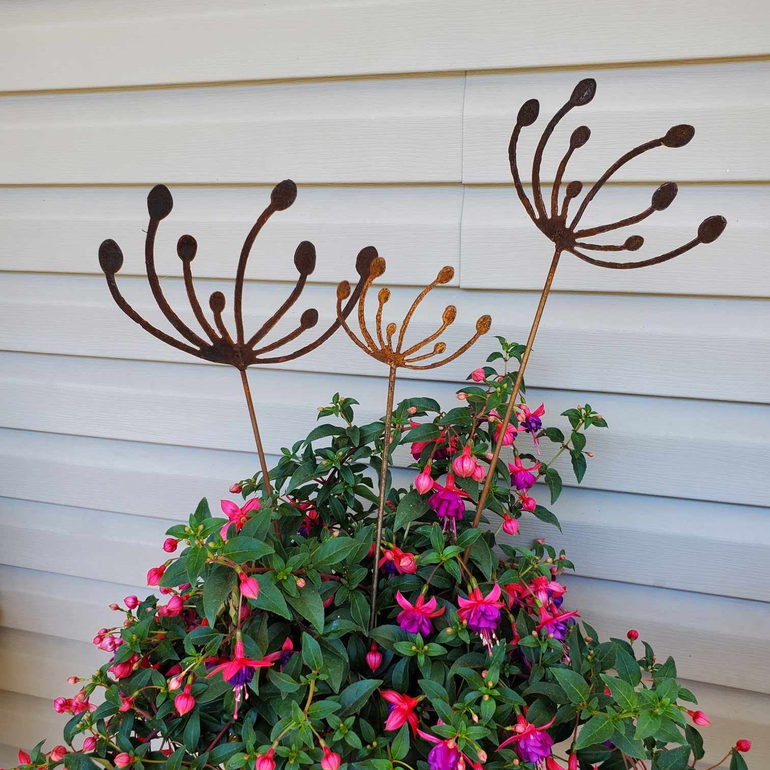 Rustic metal wind swept dandelions in a potted plant.