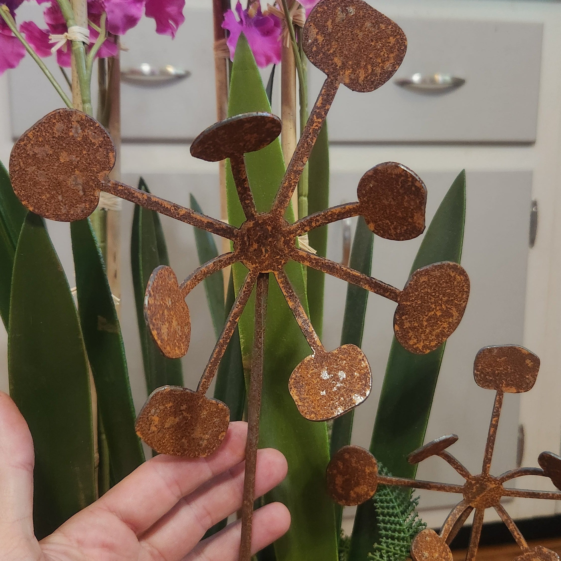 Rustic metal bendable dandelion plant stakes up close.