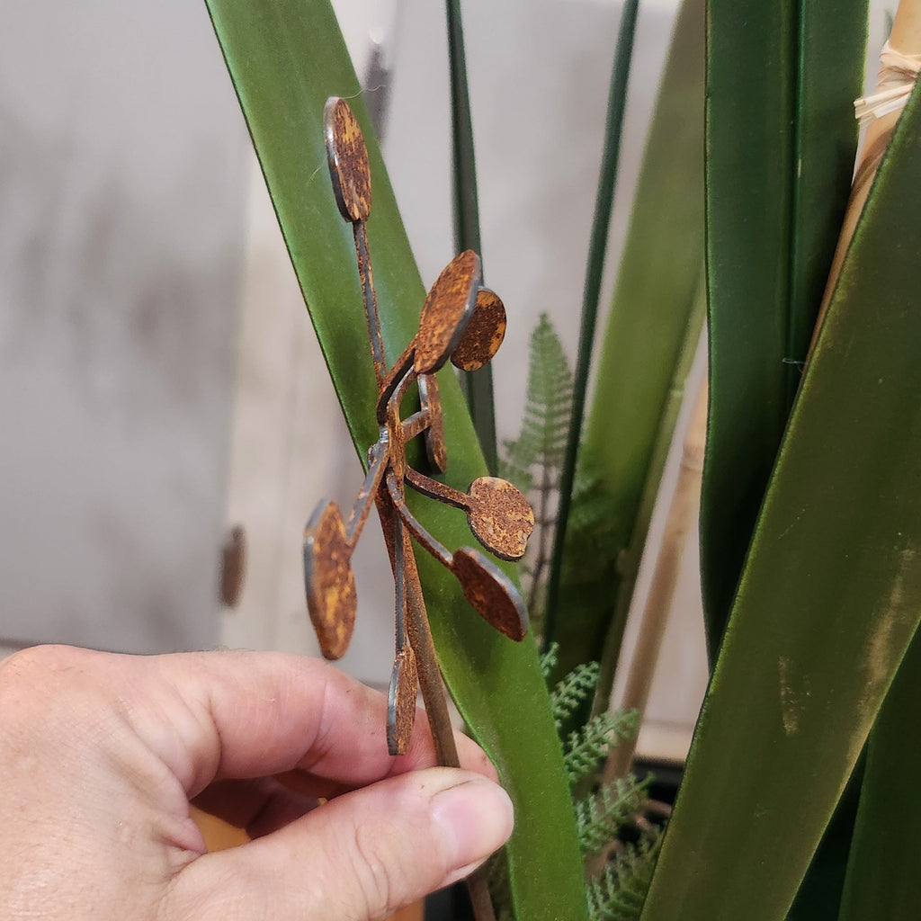 Rustic metal bendable dandelion plant stake up close to show detail.