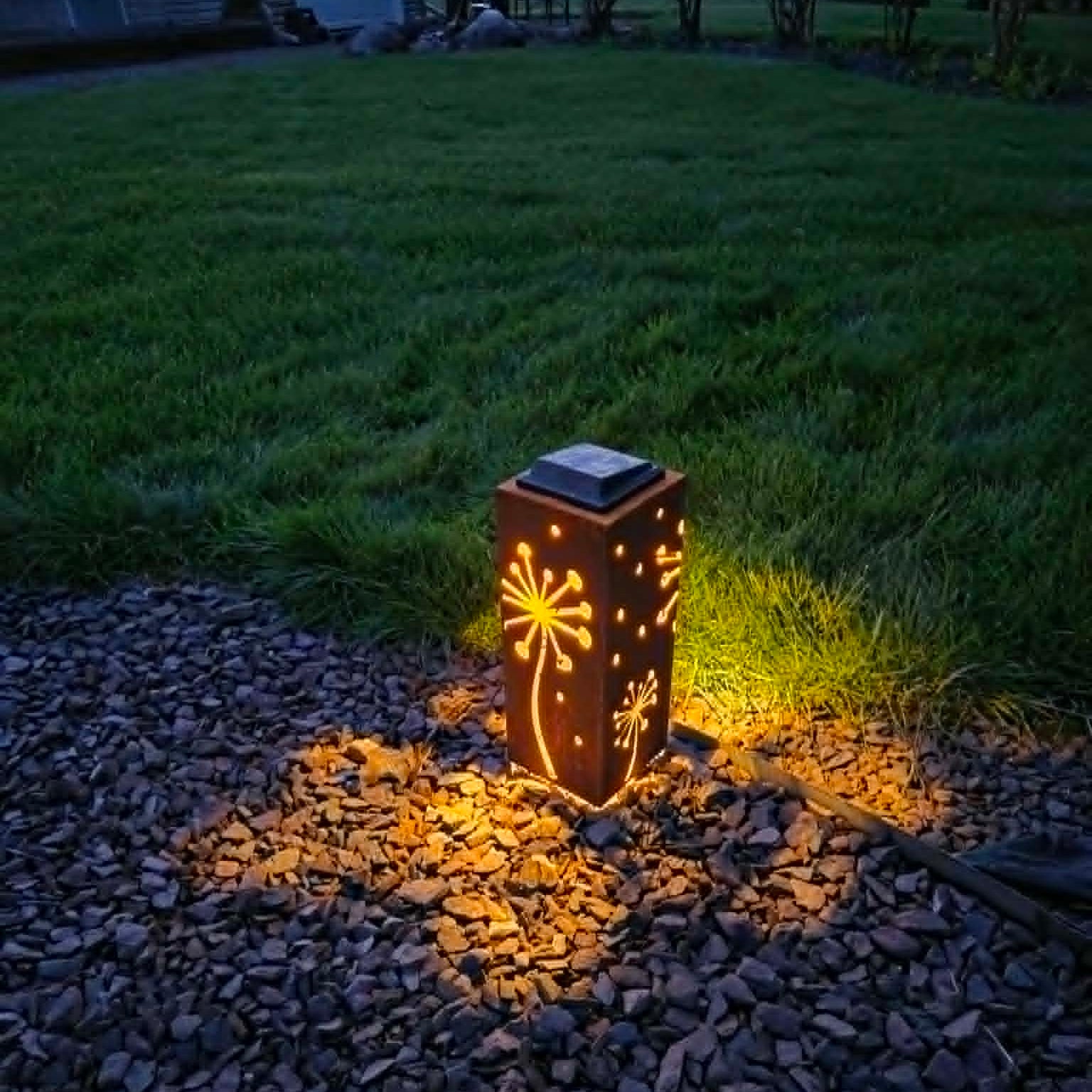 Solar-powered decorative light on a gravel path at night