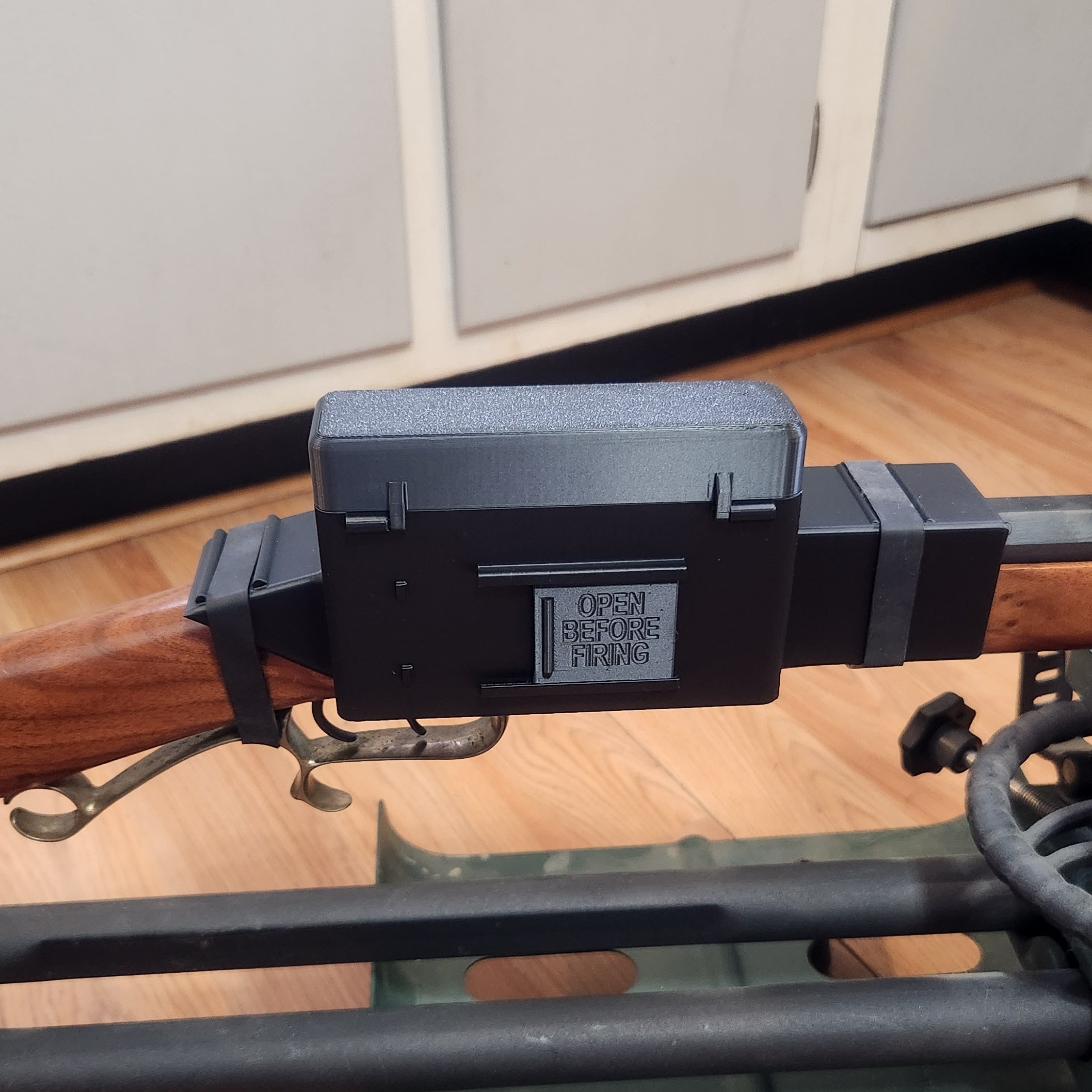 close up of the flint lock gun cover door that says open before firing