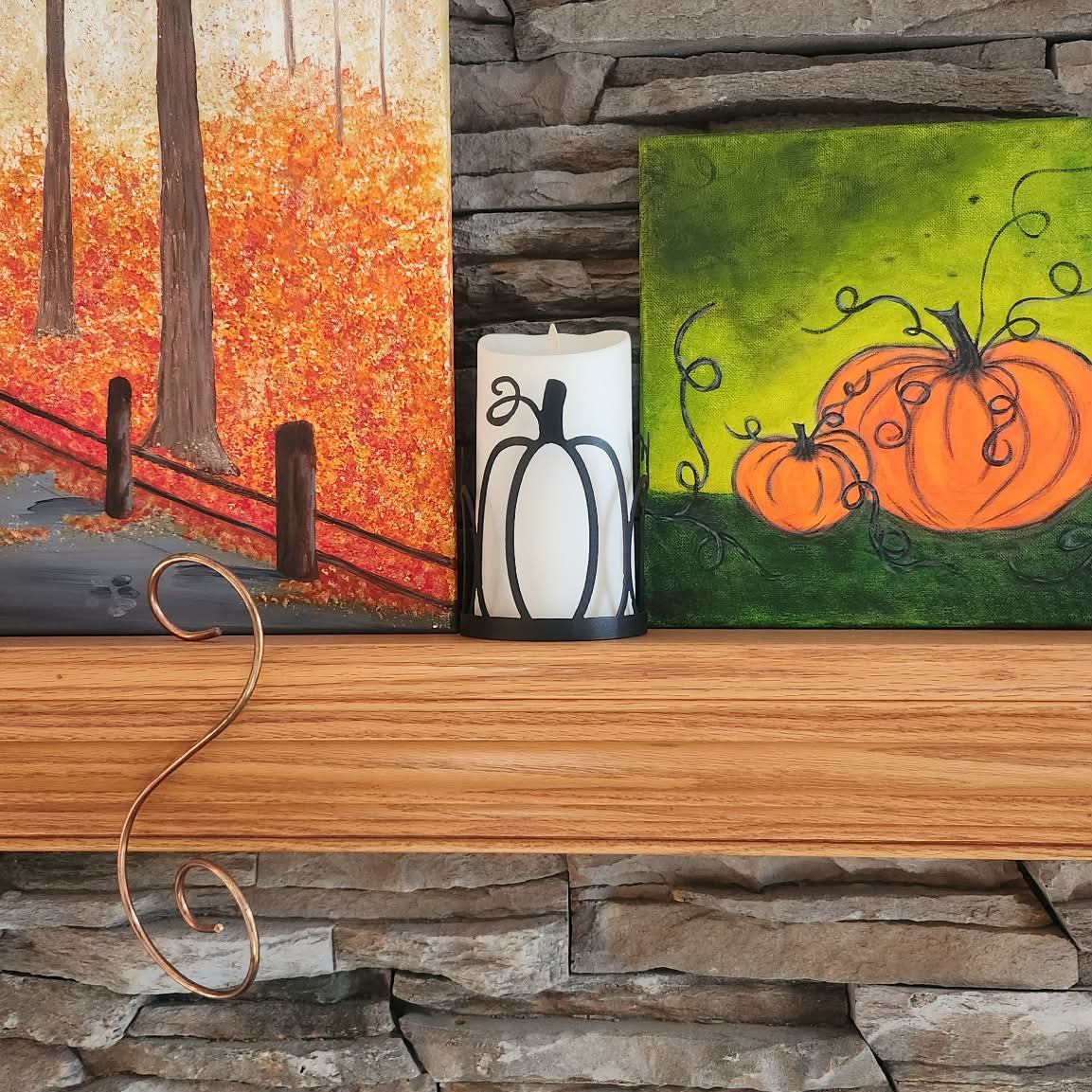 black powder coated pumpkin candle wrap on led candle sitting on a mantle